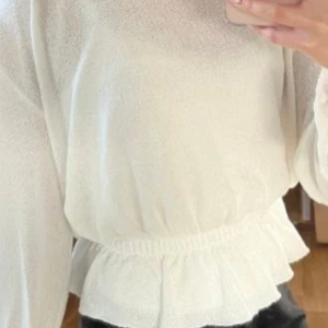 Vit tröja  - Säljer en stilren vit tröja. Tröjan har långa ärmar och en elastisk midja som ger en fin passform. Perfekt för en avslappnad look.