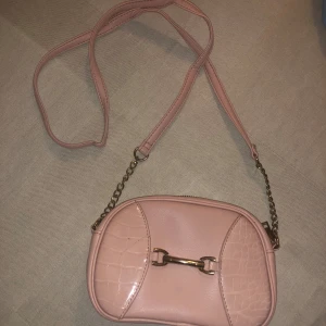 Rosa väska  - Rosa väska, har lite längre band, har dragkedja 
