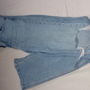 Ljusa jeans med slitningar - Snygga ljusblå jeans med slitningar och hål på knäna