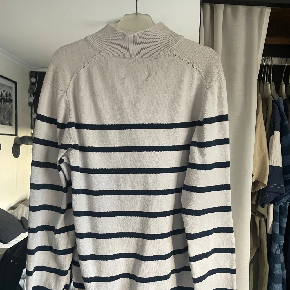 Säljer en stilren randig tröja från bondelid. Tröjan har en dragkedja vid halsen och långa ärmar. Perfekt för en avslappnad stil.. Neuletakit & Villapaidat.