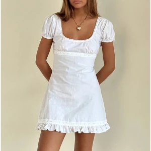 Vit kortklänning med volangdetaljer - Helt oanvänd klänning från motel rocks som är slutsåld i xs. Perfekt till student eller skolavslutning!  Superfin men säljer då jag har köpt en annan💗