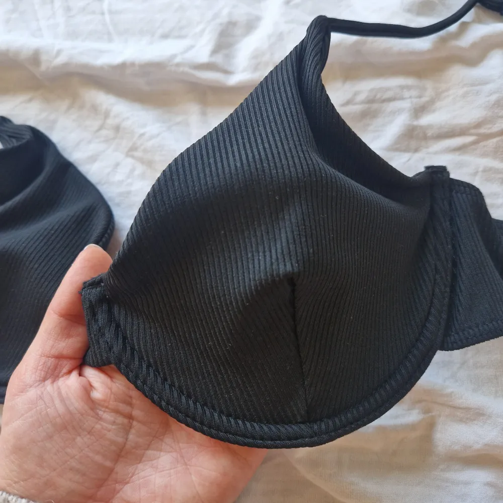 Snygg svart bikiniöverdel med ribbad struktur och justerbara axelband. Perfekt för en stilren look på stranden eller vid poolen. Enkel att matcha med olika underdelar. Passar en C cupa❤️. Muu.