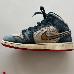 Nike Air Jordans med kartmönster - Unika Nike Air Jordans med ett coolt kartmönster i beige och blått. Skorna har en gyllene swoosh och röd sula. Perfekta för dig som vill sticka ut med en annorlunda design. Snörning framtill för en säker passform.