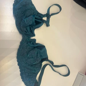 Teal spets-bh - Snygg teal bh med spetsdetaljer och justerbara axelband. Perfekt för att lägga till en touch av elegans i din garderob.