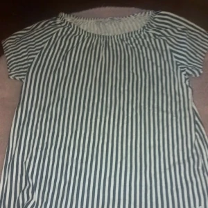 Randig kortärmad topp - Säljer en randig kortärmad topp med svartvita ränder. Toppen har en rund halsringning och är perfekt för en avslappnad stil. Passar bra till jeans eller shorts för en enkel look.