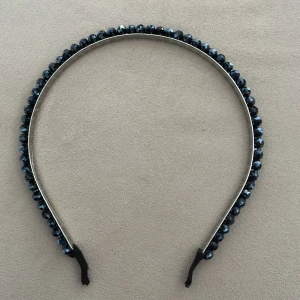Diadem med marinblåa glänsande pärlor - Helt oanvänd köpt i Grekland. Elegant diadem dekorerat med marinblåa pärlor. Perfekt för att ge en stilfull touch till din look. Diademet har en smal design och är lätt att bära.