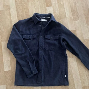 Mörkblå overshirt från Jack & Jones - Säljer en marinblå overshirt från Jack & Jones. Klockren till vår och varmerä väder eller för lager på lager. Väldigt bra skick och pris kan diskuteras. 