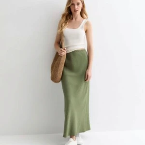 Olivgrön kjol - Olivgrön kjol med en smickrande silhuett. Den har en bekväm passform och en elegant längd som passar både vardag och fest. Storlek 38/40 Skick: ny utan tags Nypris: 499 kr