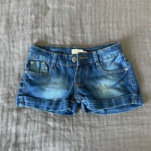 Lågmidjade jeansshorts  - Snygga blå jeansshorts med låg midja och unika detaljer. Shortsen har super skönt och stretchigt material och är i storlek 40 men skulle säga att de är i 36/S. De passar på mig som vanligtvis har 38/M men de sitter ganska tight. Perfekta till sommaren!