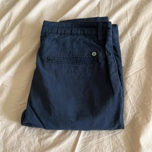 Mörkblå chinos från Zara - Snygga mörkblå chinos från Zara med klassisk passform. Byxorna har bakficka med knapp och bälteshällor, perfekta för en clean och stilren look. Tillverkade i mjuk bomull för skön känsla hela dagen.