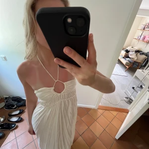 H&M långklänning med knyt och halterneck - Superfin vit långklänning från H&M med halterneck och knytning framtill. Den går att knyta på olika sätt :) nyskick. 