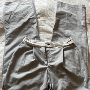 Ljusgrå kostymbyxor med vit linning - Snygga ljusgrå kostymbyxor med rak passform och vit kontrastlinning i midjan, aldrig använda eftersom de inte passade🌸