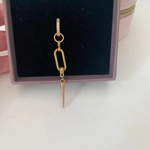 L8hasselblad örhängen i guld.  - Säljer ett par trendiga guldiga örhängen med glittrande strass på ringen, en avlång länk i mitten och en cool spike-formad hängande detalj. Perfekta för dig som vill sticka ut med en edgy och modern stil. Köpta på plick för 800 men nypris är 1000. Jag säljer båda för 500❤️