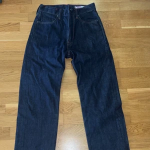 G-Star Jeans - Säljer ett par mörkblå jeans från G-Star RAW med klassisk femficksdesign och snygga kontrastsömmar. Jeansen har rak passform och är tillverkade i slitstarkt denim. Perfekta för dig som gillar en stilren och tidlös look.