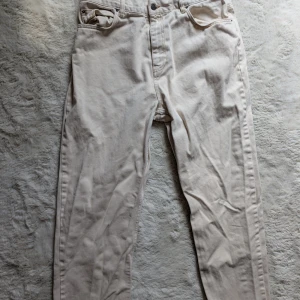 Vita raka jeans i bomull - Snygga vita jeans med raka ben och klassisk femficksdesign. Byxorna är tillverkade i mjuk bomull och har en neutral, ljus ton som passar till det mesta. Perfekta för dig som gillar en clean och enkel stil.