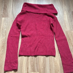 Vinröd stickad tröja - Skön vinröd stickad tröja från Bik Bok i ullblandning. Tröjan är off-shoulder med långa ärmar. Köparen står för fraktkostnad om det uppkommer.