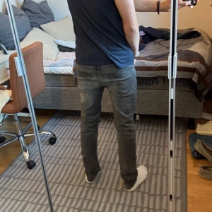 Grå/svart jeans från J.Lindeberg - Snygga grå/svrat jeans från J.Lindeberg i klassisk femficksmodell. W30 L32, Jeansen har en vanlig passform men lite mer åt slim hållet, och är tillverkade i mjukt denimtyg med lätt tvättad look. Perfekta för dig som gillar vanliga snygga jeans. Köpta för 1299 kr. 