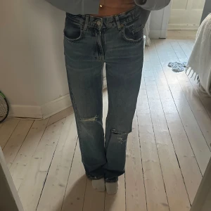 Blåa raka jeans med slitningar - Low rise super coola jeans! Ingen tecken på användning och knappt använd!