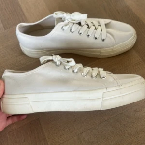 Vita sneakers från Vagabond, stl 41 - Snygga vita sneakers från Vagabond i klassisk modell med rund tå och platt sula. Skorna är i canvas med vita snören och silverfärgade öljetter. Perfekta för en clean och stilren look. Aldrig andvända tyvärr men dom är u väldigt bra skick 💕💕