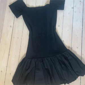 Smockad Off shoulder klänning - Jättesnygg klänning från HM med volang längst ner. Aldrig andvänd med prislappen kvar. Storlek XS.