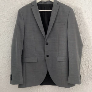 Grå super slim kavaj Jack & Jones - Snygg grå kavaj från Jack & Jones i super slim passform.  Kompletterar kostymbyxor 