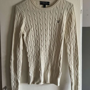 Vit kabelstickad tröja från GANT - Säljer en vit kabelstickad tröja från GANT i stretchig bomull. Fint skick och har ej använts mycket!💕