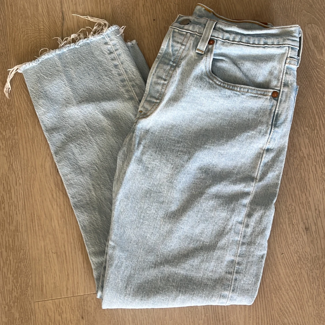 Ljusblå Levi's 501 jeans med råa benslut