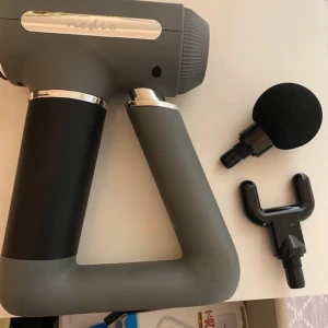 Massagepistol från Nedis - Säljer en grå och svart massagepistol från Nedis med digital display och två utbytbara massagehuvuden. Ergonomiskt handtag och enkel att använda med tydliga knappar för styrka och av/på. Perfekt för återhämtning efter träning. Jag har inte anvånt så många gånger och fantastiskt skick
