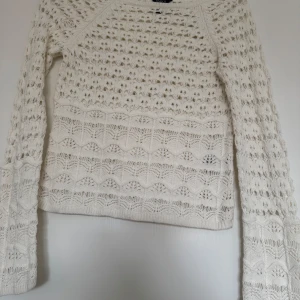 Vit stickad tröja från Lindex - Säljer en vit stickad tröja från Lindex i storlek XS. Tröjan har ett vackert hålmönster och långa ärmar. 