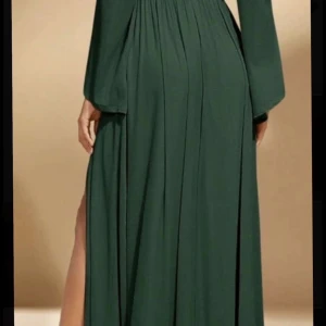 Mörkgrön glittrig långklänning med långa ärmar - Säljer en elegant mörkgrön långklänning med diskret glittrigt tyg och långa ärmar. Klänningen har en lös passform och faller snyggt längs kroppen. Perfekt för speciella tillfällen när du vill sticka ut lite extra.