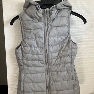 Grå dunväst med huva från ONLY - Snygg grå dunväst från ONLY med huva i storlek xs 