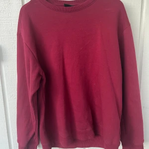 Mörkröd sweatshirt från H&M - En enkel och stilren mörkröd sweatshirt från H&M med relaxed fit. Tröjan har rund halsringning, långa ärmar och ribbade muddar vid ärmslut och nederkant. Perfekt för en avslappnad look. —— Använd 1-2 gånger då den är för stor för mig och därmed i mycket gott skick. Tröjan är i storlek M men är stor i storleken.