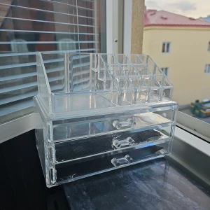 Transparent sminkförvaring med lådor och fack - Ord pris 599kr. Säljer en transparent sminkförvaring i akryl med tre utdragbara lådor och flera små fack upptill för borstar, läppstift eller andra sminkprodukter. Perfekt för att organisera smink på sminkbordet. Modern och stilren design. Lite sprucken i hörnet, se bilden, inte vasst. Säljer därför billigt.
