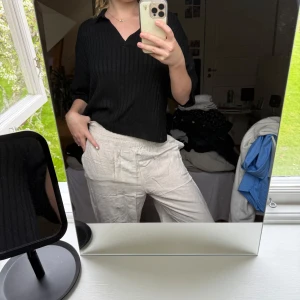 Beiga linnebyxor med resårmidja - Säljer ett par beiga linnebyxor med avslappnad passform och resår i midjan. Byxorna har utsvängande ben och är tillverkade i ett tunt, luftigt material som passar perfekt för varmare dagar. Enkla att matcha med olika toppar för en chill look.