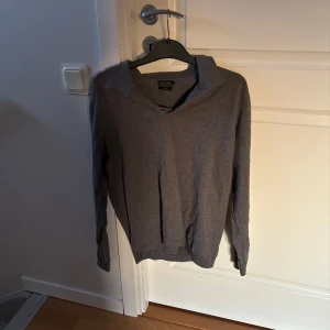 Grå v-ringad tröja från Massimo Dutti - Säljer en stilren grå v-ringad tröja från Massimo Dutti i mjuk bomullsblandning. Perfekt för lager-på-lager och passar till många olika outfits. Klassisk passform med långa ärmar. skön och pris kan diskuteras.