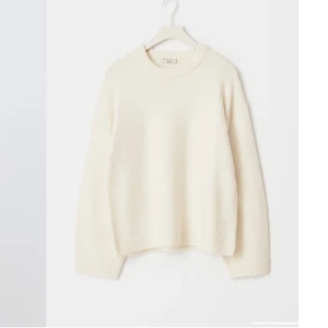 Vit stickad tröja från Gina Tricot - Mysig vit stickad tröja från Gina Tricot i ullblandning. Tröjan har rund halsringning, långa ärmar och ribbade muddar vid ärmslut och nederkant. Perfekt för kyliga dagar och enkel att matcha med olika outfits. Den har en liten fläck där fram, men man ser den knappt