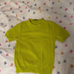 Gul neon mönstrad topp - Säljer en cool gul kortärmad tröja från Zara med strukturmönster över hela tyget. Säljer då den är för liten, färgen är neon. Passar XS-S