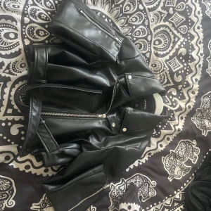 Svart skinnjacka från Monki - Säljer en svart skinnjacka från Monki i storlek M. Jackan har klassisk bikerstil med dragkedja och krage, samt silvriga detaljer. Nypris 900 Perfekt för våren 💗.