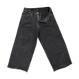 Svarta Astro Loose Baggy Jeans från Weekday - Säljer ett par svarta Astro Loose Baggy Jeans från Weekday. Byxorna har breda ben, råa kanter nertill och knäppning med knappar. 
