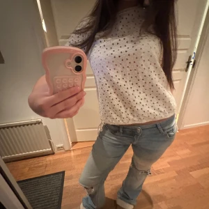 Vit kortärmad topp med hålmönster - Intressekoll på en vit kortärmad topp med hålmönster. Toppen har rund halsringning och är gjord i ett lätt material som passar perfekt till jeans eller kjol. Enkel och stilren design som funkar till många tillfällen.