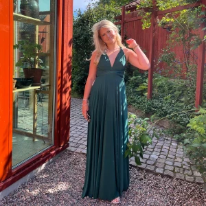 Klänning - Mörkgrön långklänning från bubbleroom, man kan ändra banden så att klänningen sitter olika (titta hemsidan GODDIVA) 