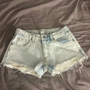Low waist Ljusblå jeansshorts med fransar  - Ljusblå jeansshorts som jag köpt i Italien så vet inte riktigt vilken butik. De står att de är storlek 28 på dom men jag tycker dom är lite mindre än så. Knappt använda och köptes för 600kr nya.