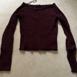 Vinröd stickad tröja från Gina Tricot - Mörkröd kabelstickad tröja från Gina Tricot med kabelstickat mönster. Tröjan har lång ärm och har en båtringning. Perfekt för kyligare dagar och enkel att matcha med jeans eller kjol. Använt ett par gånger men jätte bra skick!😍#stickattröja#mörklila#höstmode#vinterstil#secondhandfynd#tröjainspo#plickfynd#stickatärmål#tröjtrend#hållbartmode#säljespåplick#tröjatillsalu#stickatplagg#outfitinspo#plaggmedstil#långärmadtröja #trendigtjustnu#snyggatröjor #stickatälskare #plaggföralla #kabelstickad