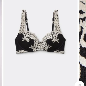 Svart och vit spets-bh från Intimissimi  - Säljer en snygg svart bh med beige spetsdetaljer och blommönster. Bh:n har breda axelband med spets och vacker design framtill. Perfekt för dig som vill ha något extra fint under kläderna.