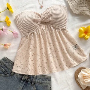 Beige tubtopp med spets från SHEIN - Söt beige tubtopp från SHEIN med virkad överdel och broderad spets nertill. Toppen är axelbandslös och har ett fint blommigt hålmönster samt twistad detalj framtill.