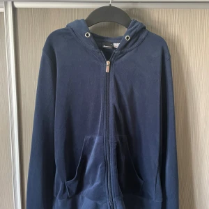 Mörkblå hoodie från Gina Tricot - Mörkblå hoodie från Gina Tricot med dragkedja framtill och huva. obs!!saknar snöre.