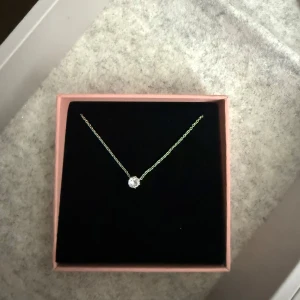 Smyckesset i silver från Edblad - Säljer ett elegant smyckesset från Edblad med halsband och armband i silverfärgad kedja och en gnistrande rund sten. Perfekt för att ge en stilren touch till din outfit. Använt ett par gånger, får ingen användning längre 