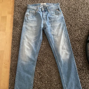 Ljusblå jeans Replay Grover straight fit - Säljer ett par ljusblå Replay Grover jeans med straight fit. Klassisk femficksmodell med dragkedja och knapp framtill. Tydlig Replay-logga vid fickan och läderpatch bak i midjan. Perfekta för dig som gillar en rak passform och snygg tvätt.