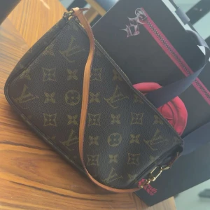 Louis Vuitton Monogram axelväska - 💓Säljer en klassisk Louis Vuitton axelväska i brunt skinn med det ikoniska monogrammönstret. Väskan har en smidig dragkedja upptill och en tunn axelrem i ljusbrunt läder. Perfekt storlek för det viktigaste och lätt att bära med sig.💓Väskan är äkta och köpt på hos soult soles i Emporia!💓