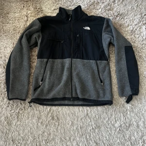 The North Face fleece - Säljer min vintage fleece från The North Face. Fleecen köpte jag i Tokyo för flera år sen och säljs nu då den inte kommer till användning. Fleecen har en mindre fläck (går nog att tvätta bort) och vid ena ärmen har bandet gått upp, annars i bra skick. Skriv vid frågor!